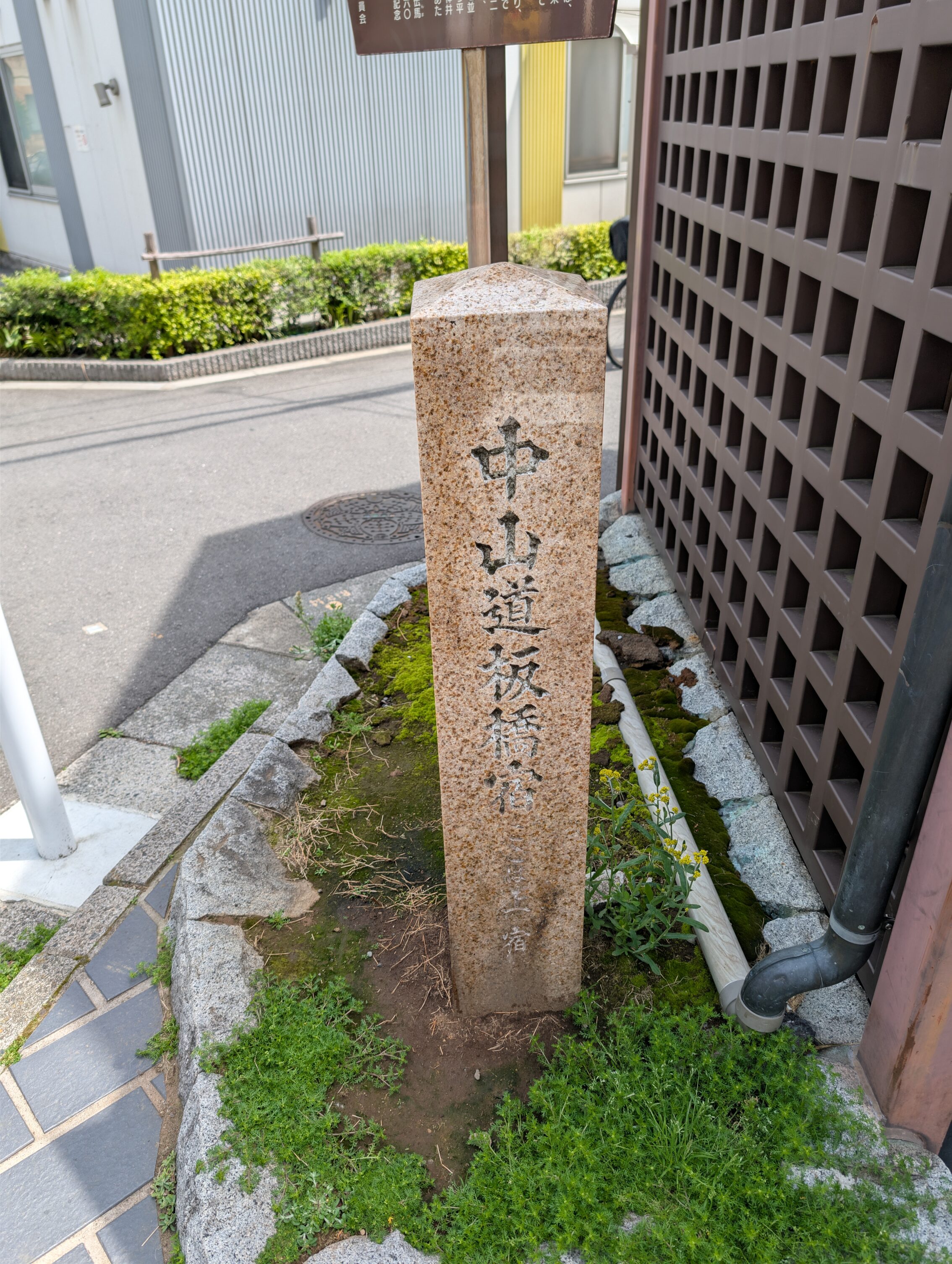 A close-up of the yellowish standing stone. It has an inscription in Japanese.