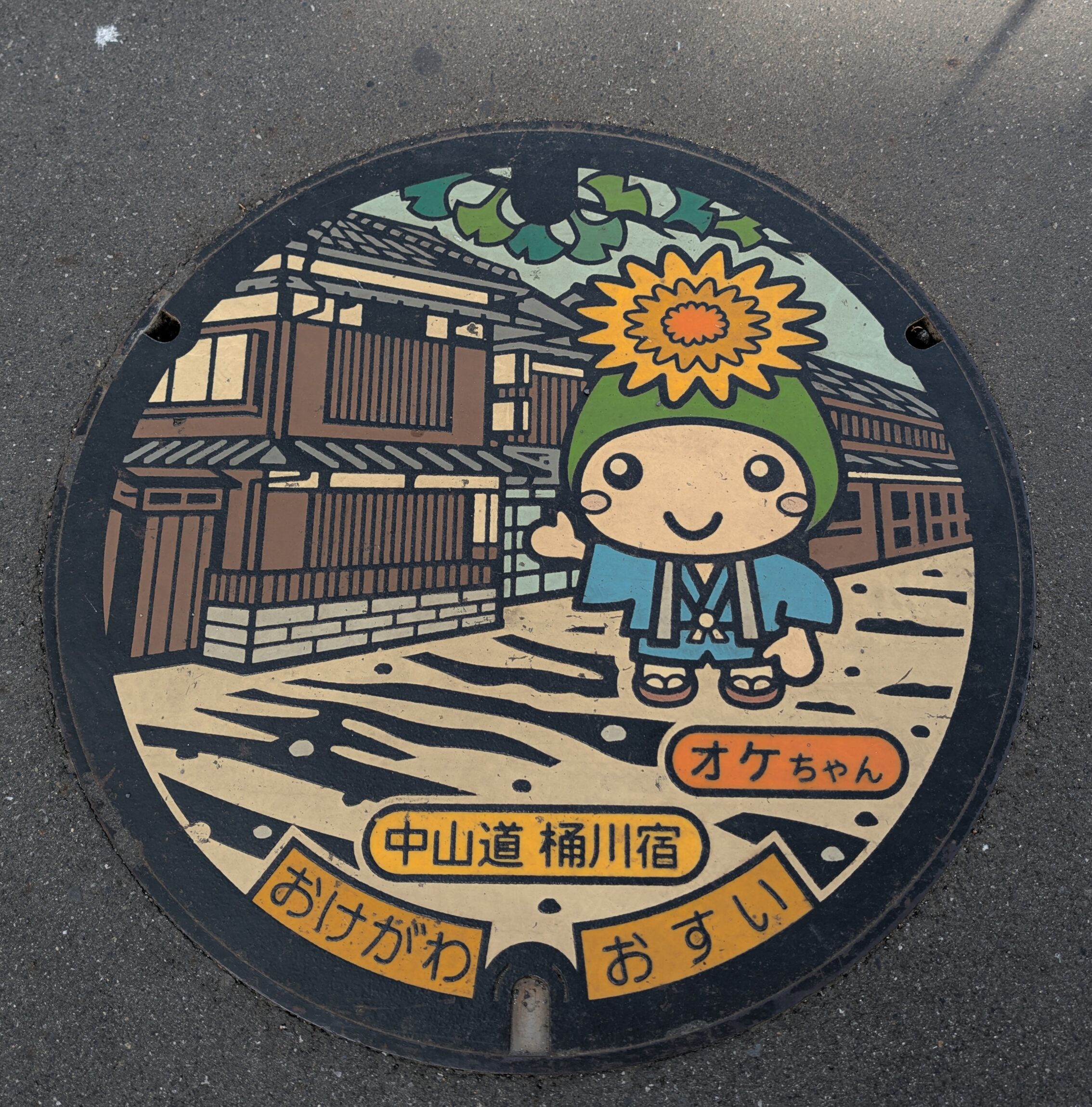 Colourful  manhole cover with a Nakasendō traveller and an Edo-period house.