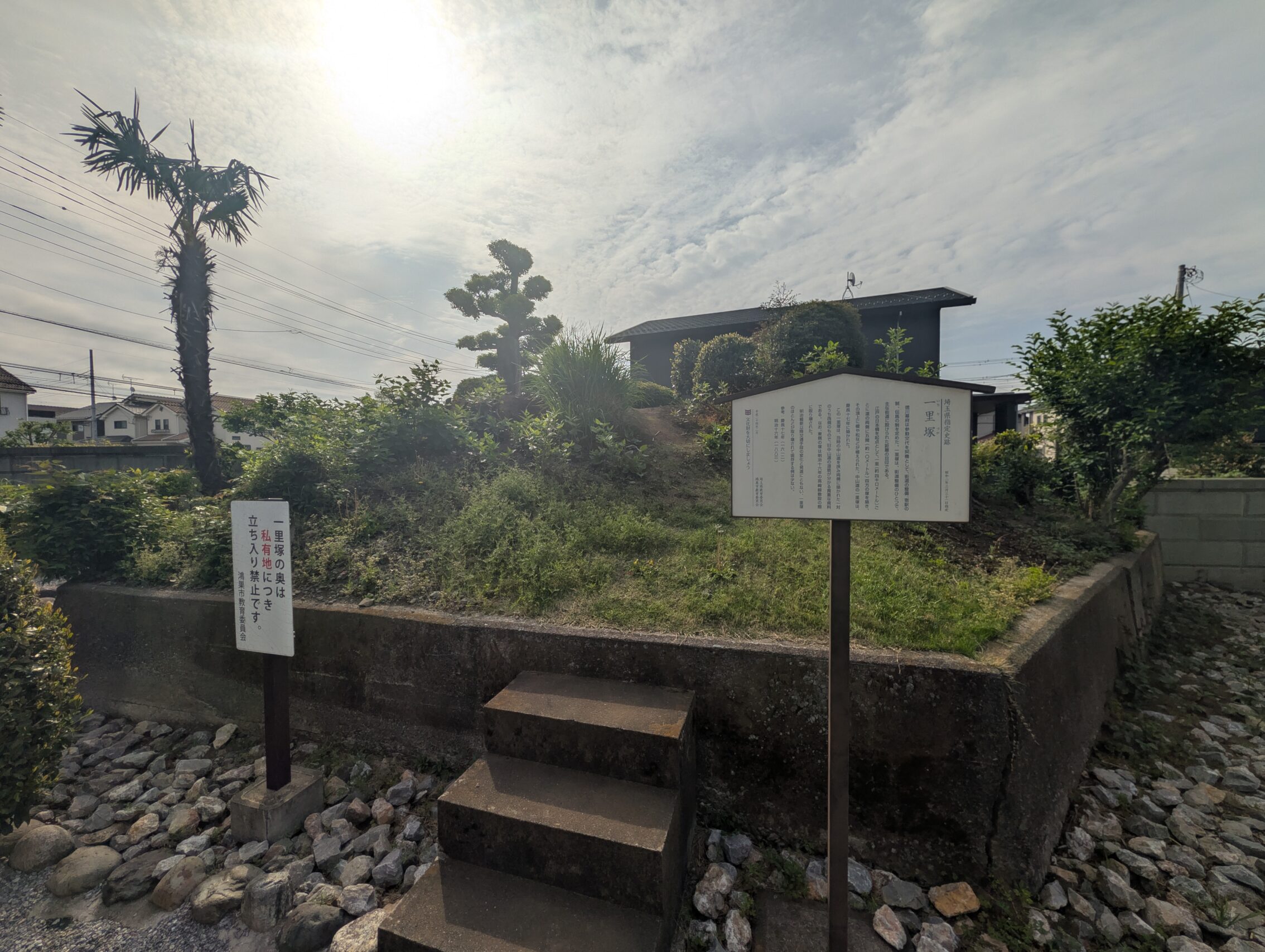 A mound with some cement steps in front of them, as well as a couple of information signs.