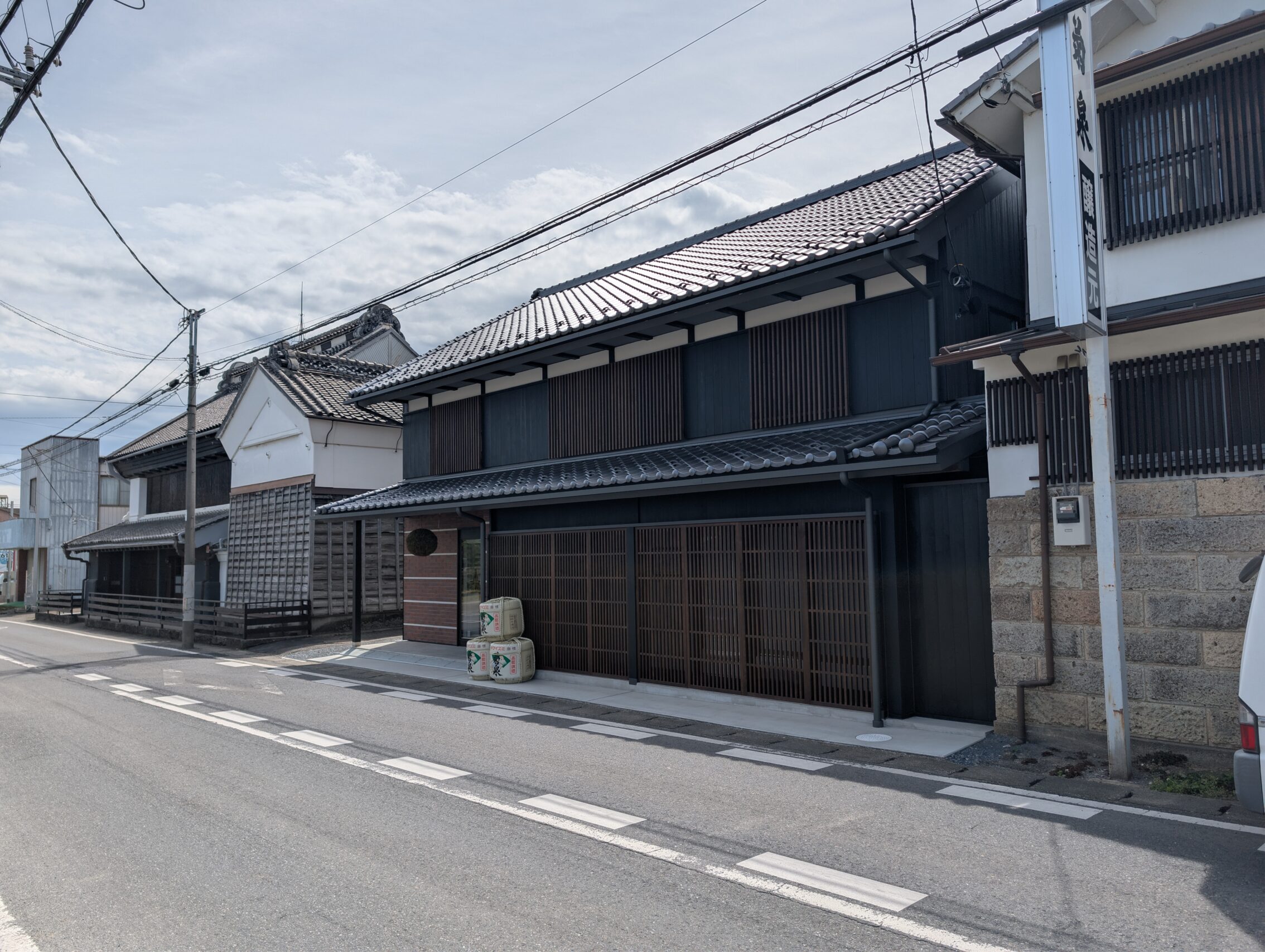 Building housing the Takizawa sake brewery. It has three large vats of sake out on the pavement.