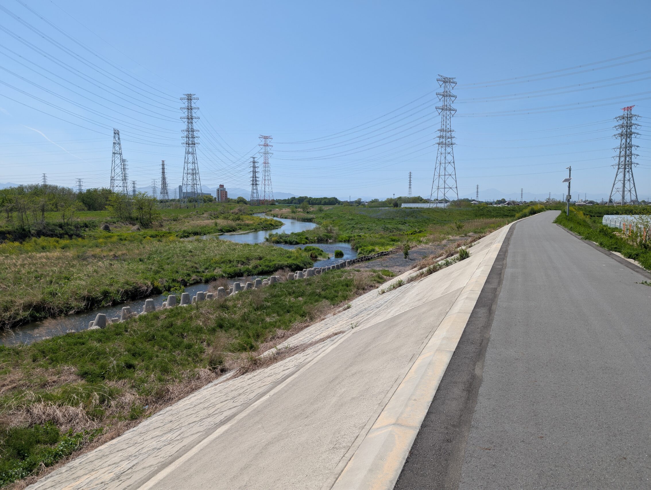 Bike lane running along an embankment, with the river on the left hand side.