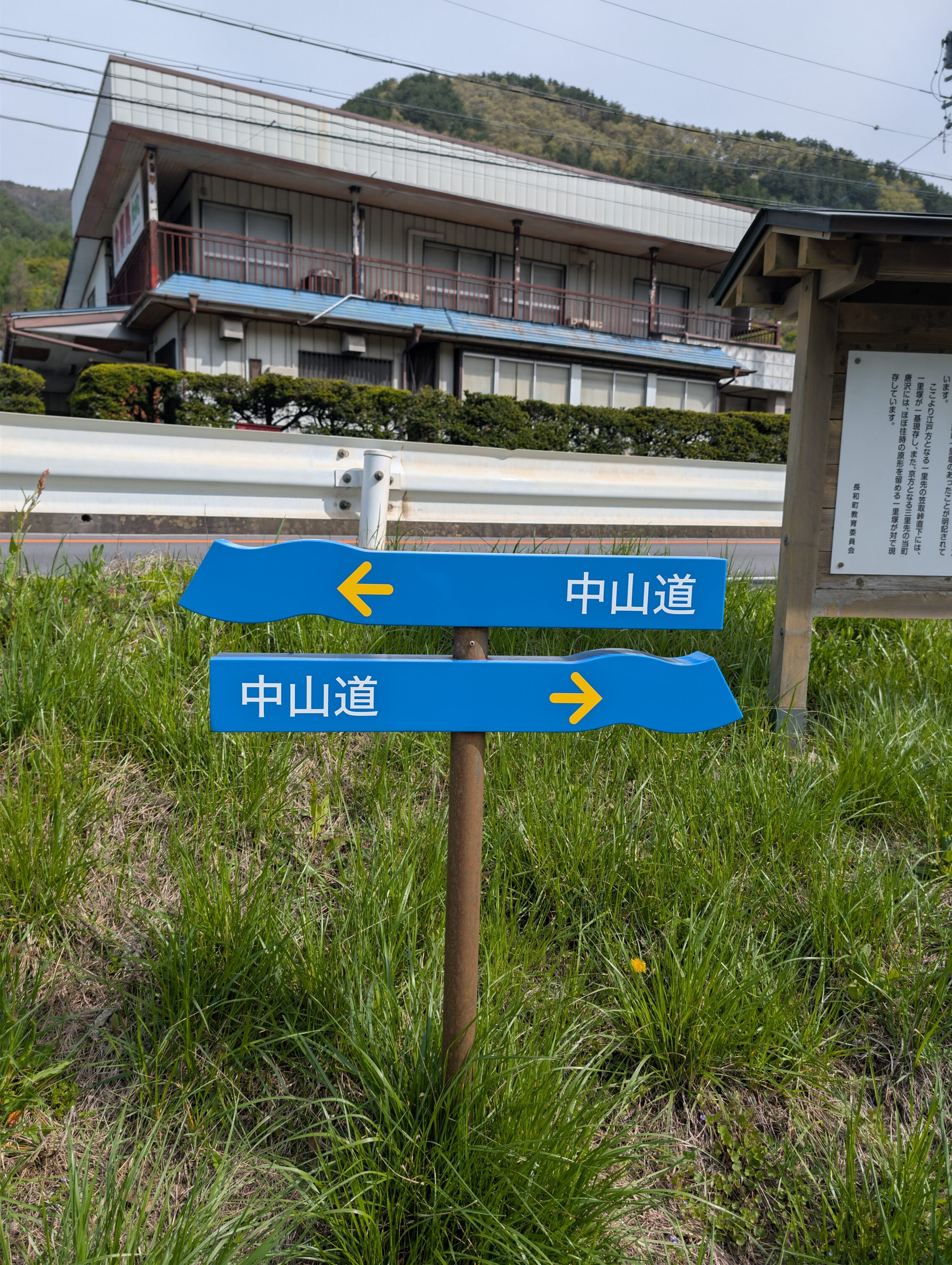 Two blue horisontal signs with wavy ends, and yellow text and arrows.