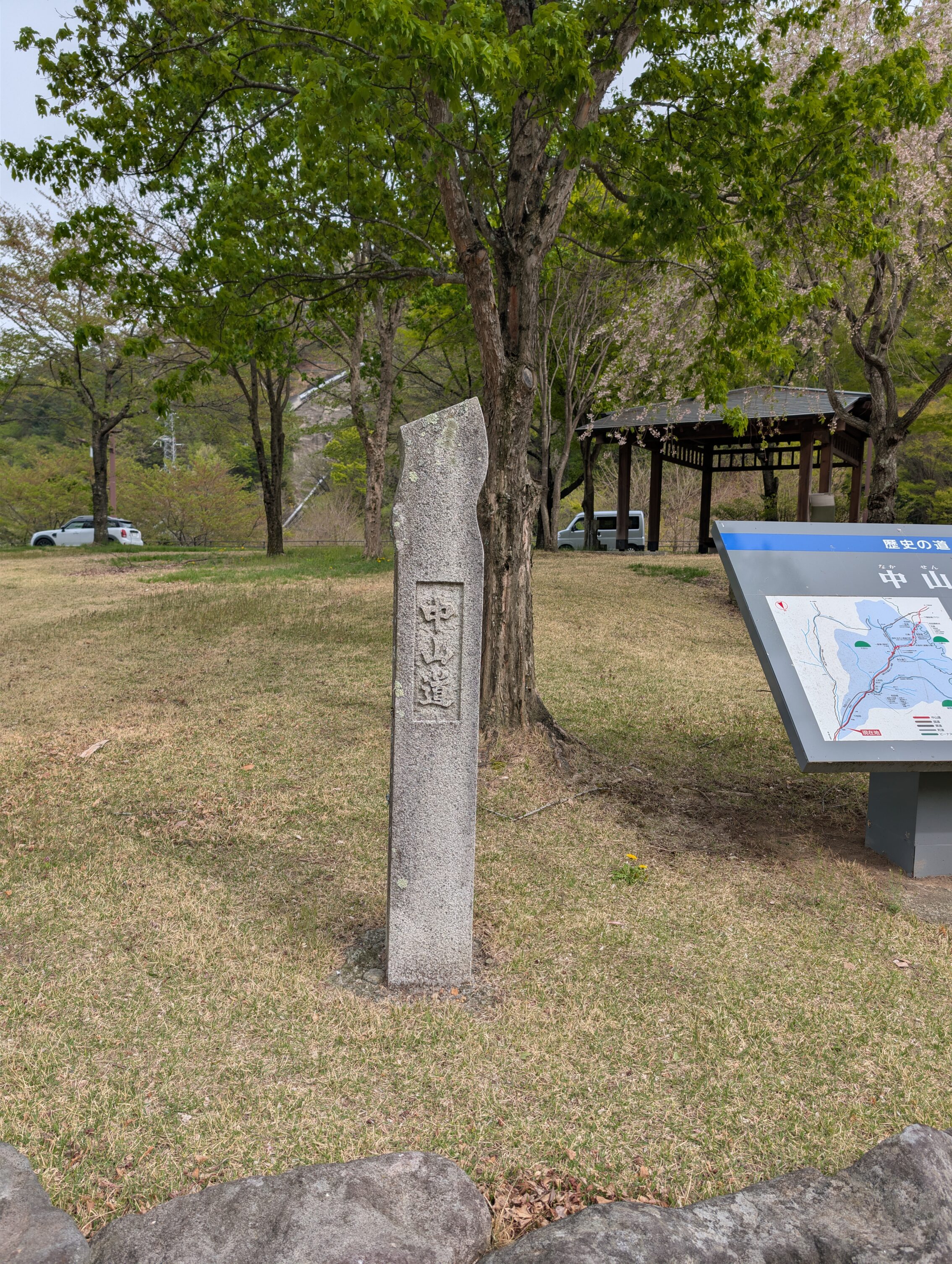 Stone pillar with wavy top end, and words carved horisontally.