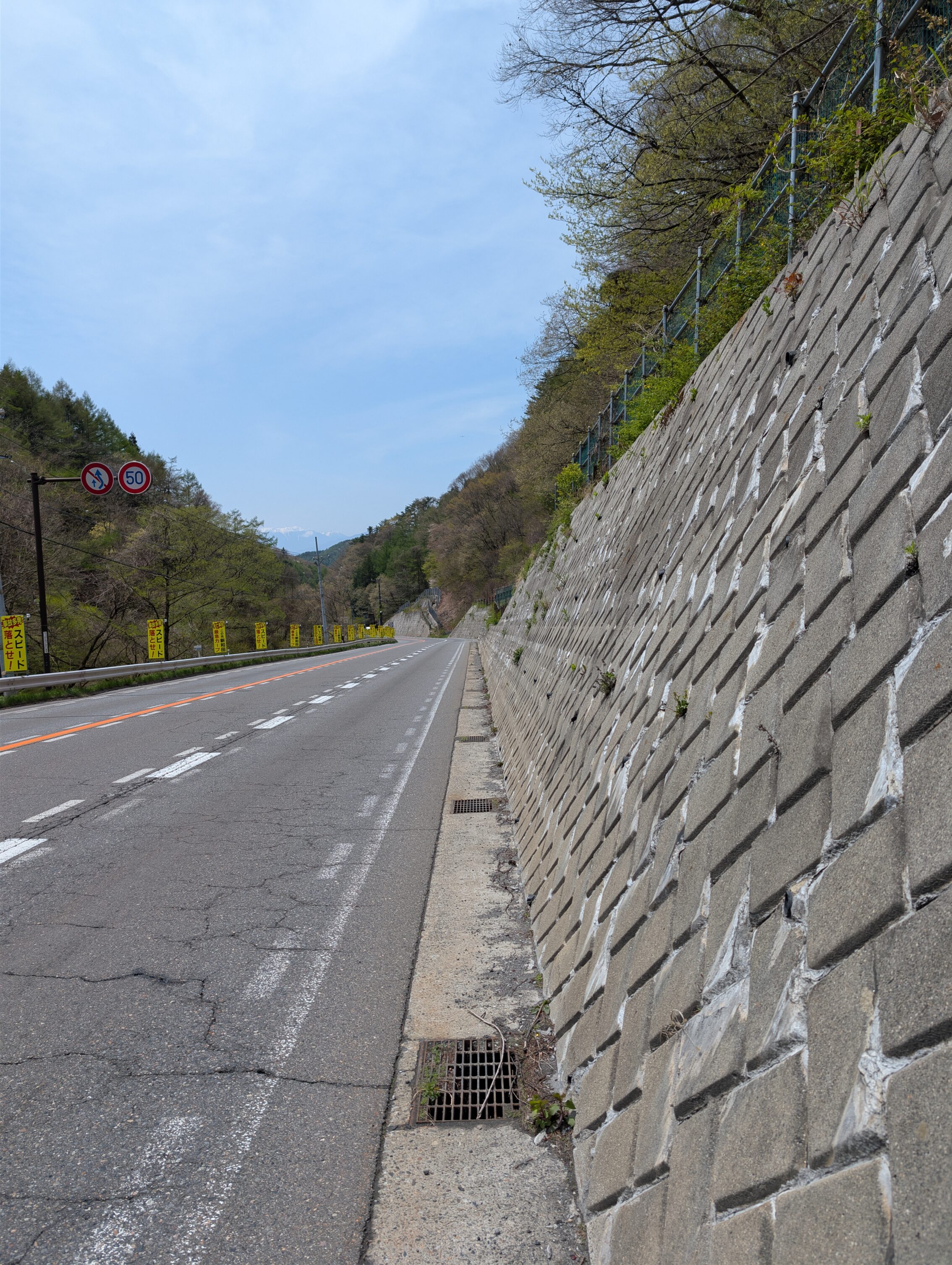 A highway with a cement wall to the right.