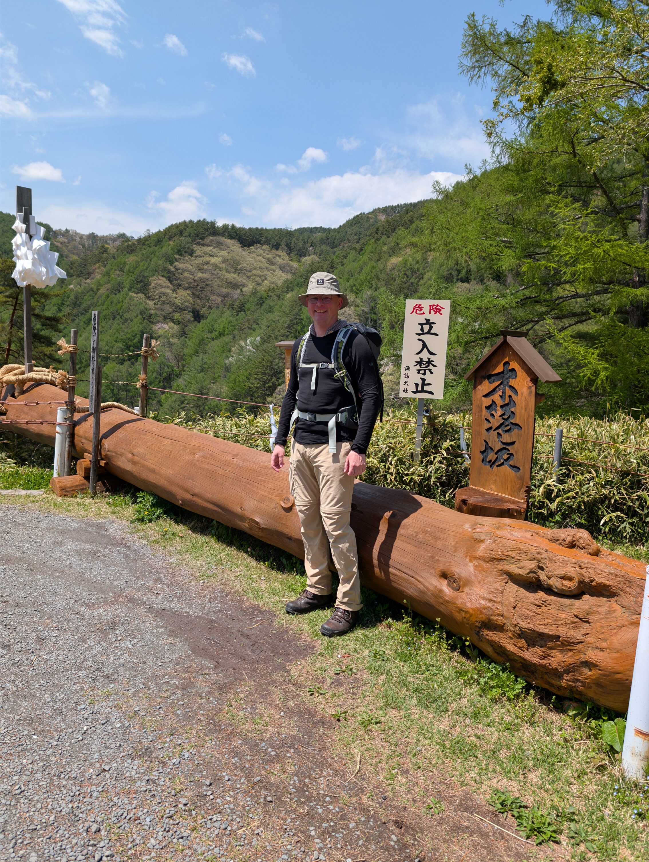 The intrepid hero standing in front of a trunk of an old felled Japanese cedar tree.