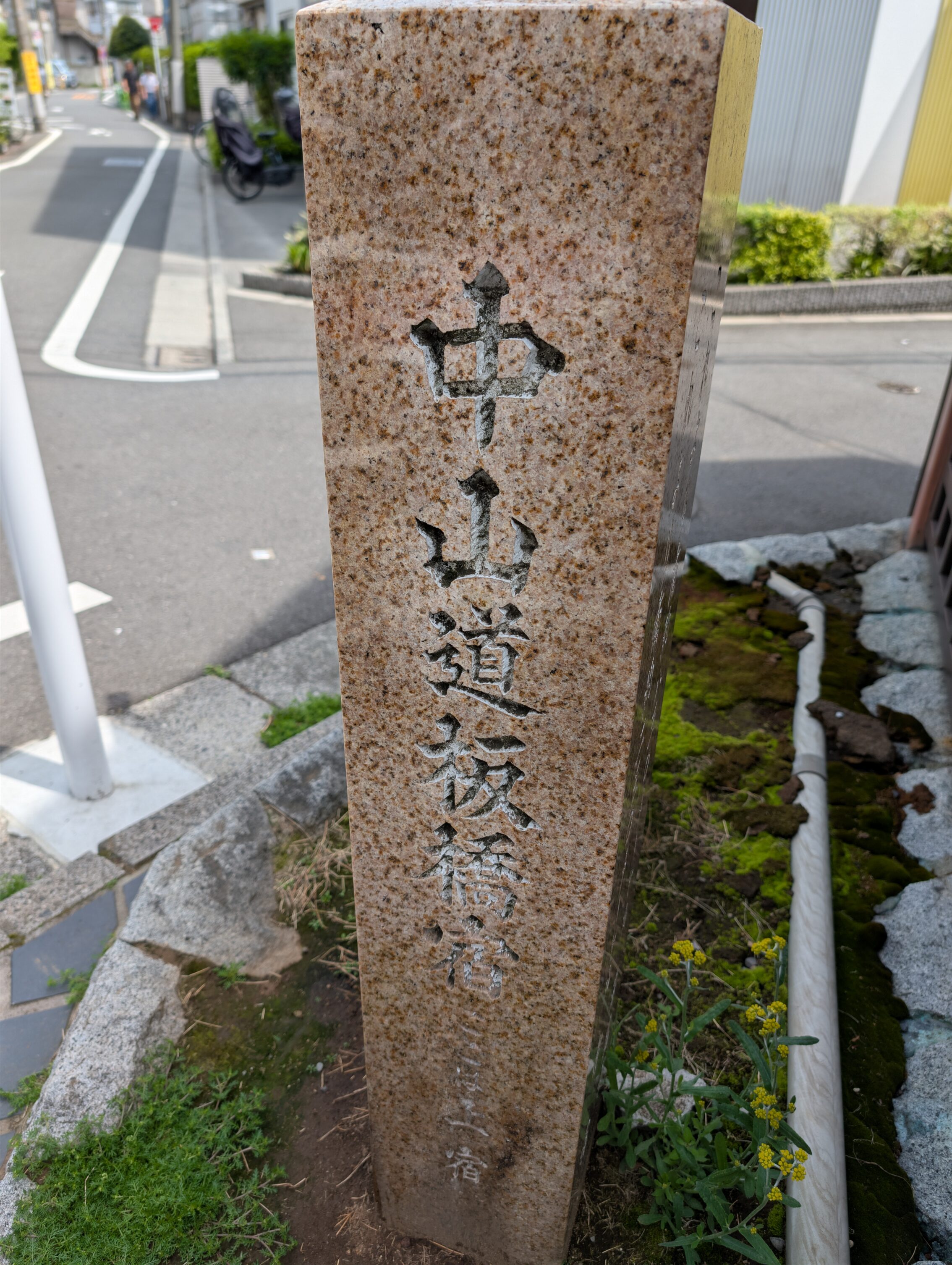 A stone marker next to a street.