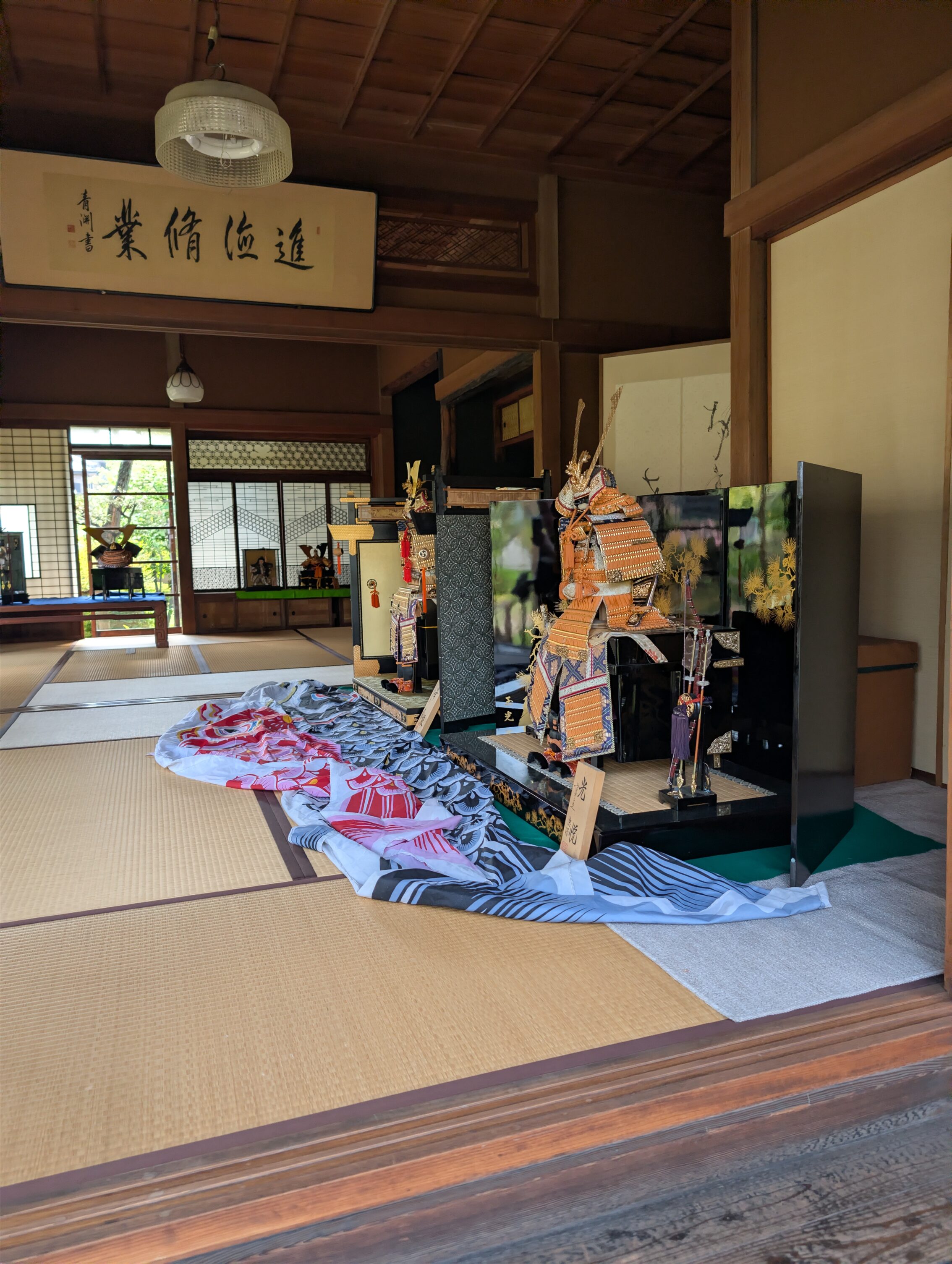 View of a room inside the mechant house. On display is armour and formal-wear. 