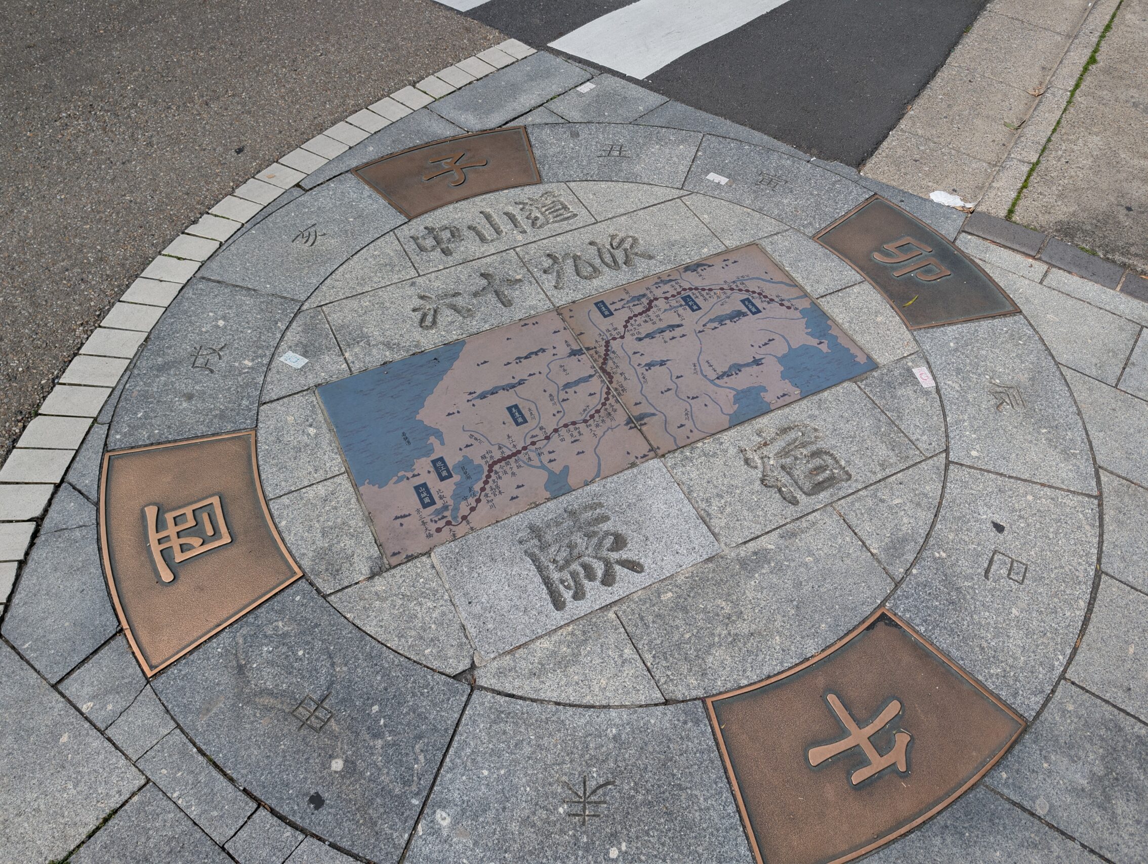 A large compass rose set in the pavement, with a map of Japan showing the whole Nakasendō route.
