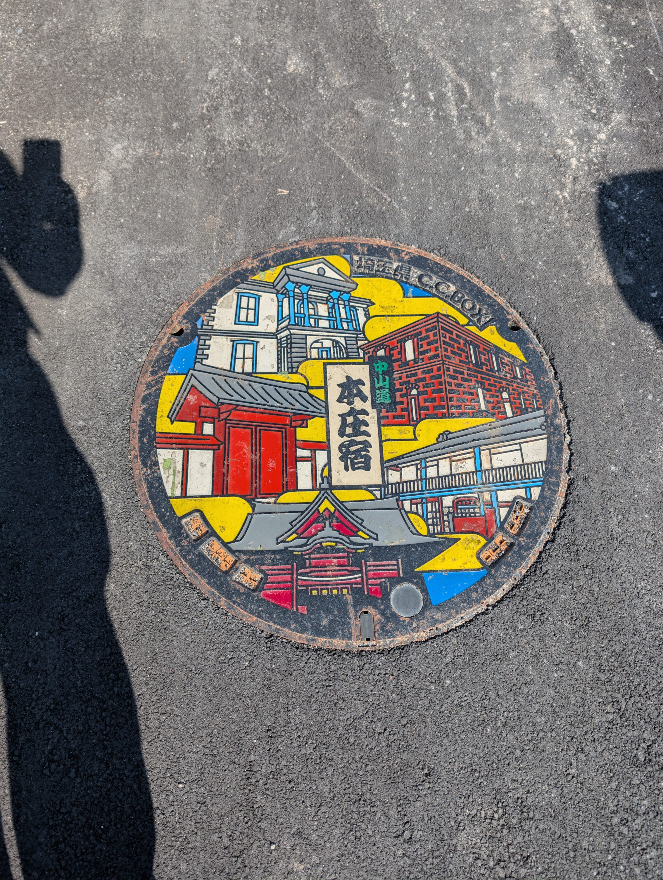 Manhole cover with a lot of buildings from different time periods.