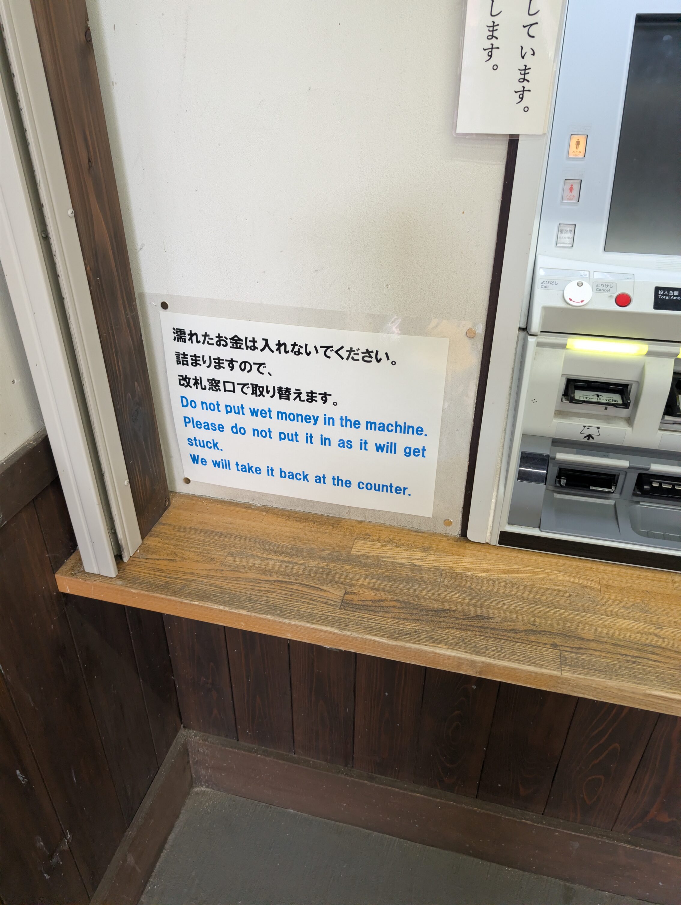 A ticket machine with a sign that warns about using wet bills as they gum up the system.