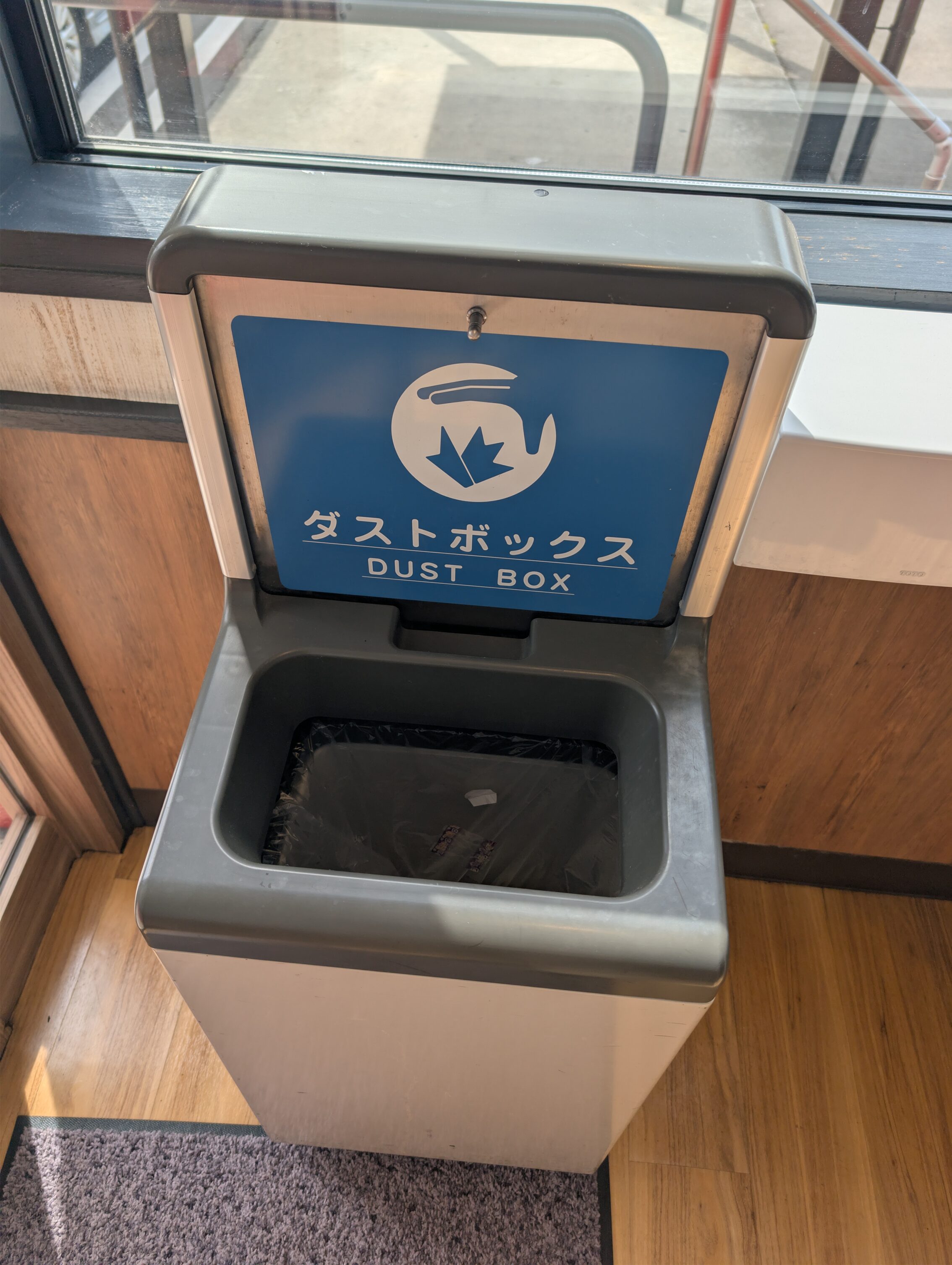 A rubbish bin with a sign saying "Dust box"