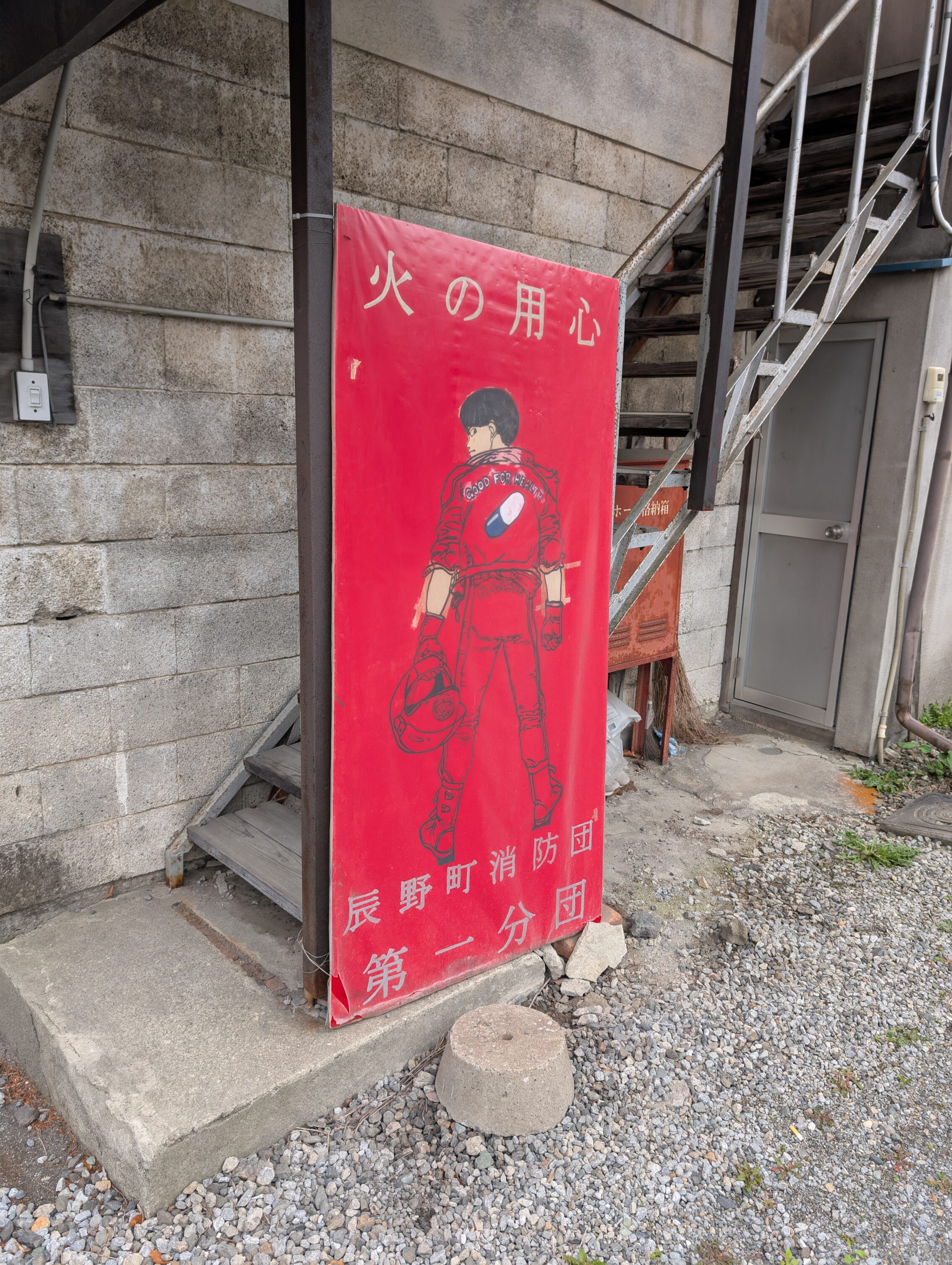 A large outdoors poster of Akira, against a concrete background.