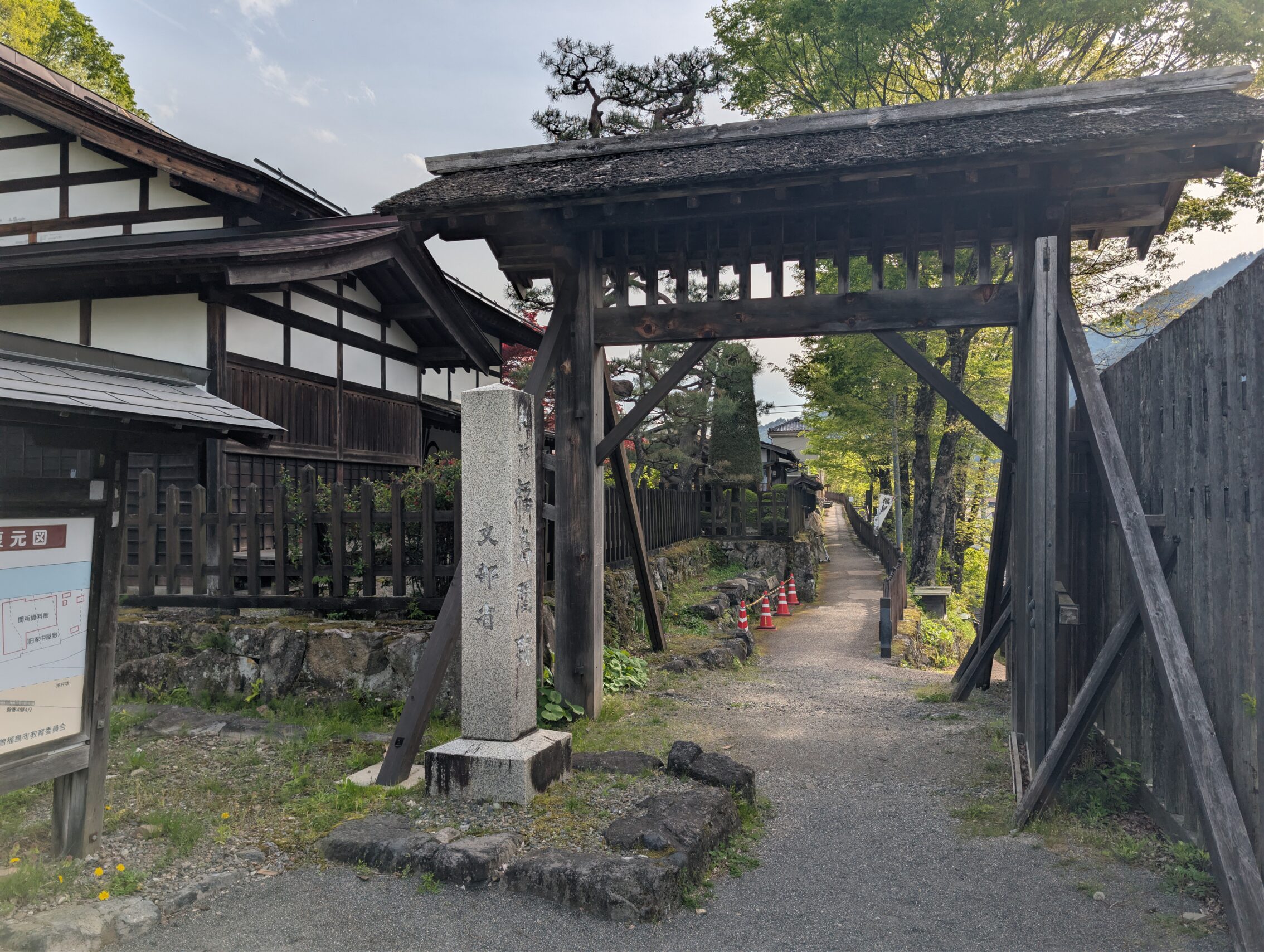 A wooden gate with a building in the background.