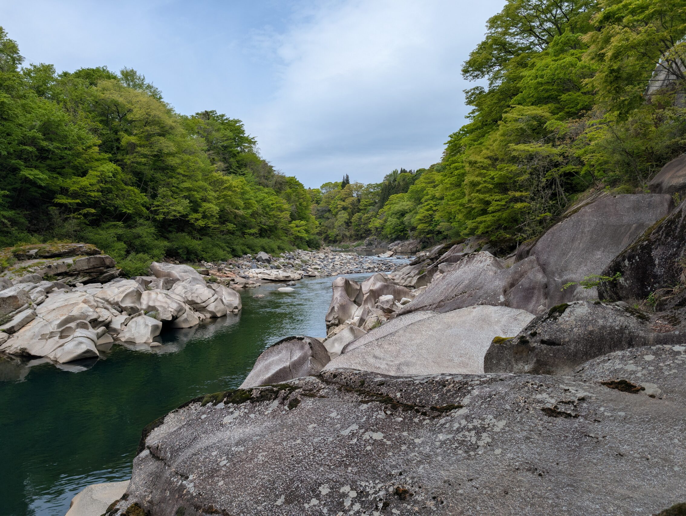 The Kiso river from the river bed, with granite rocks and trees.