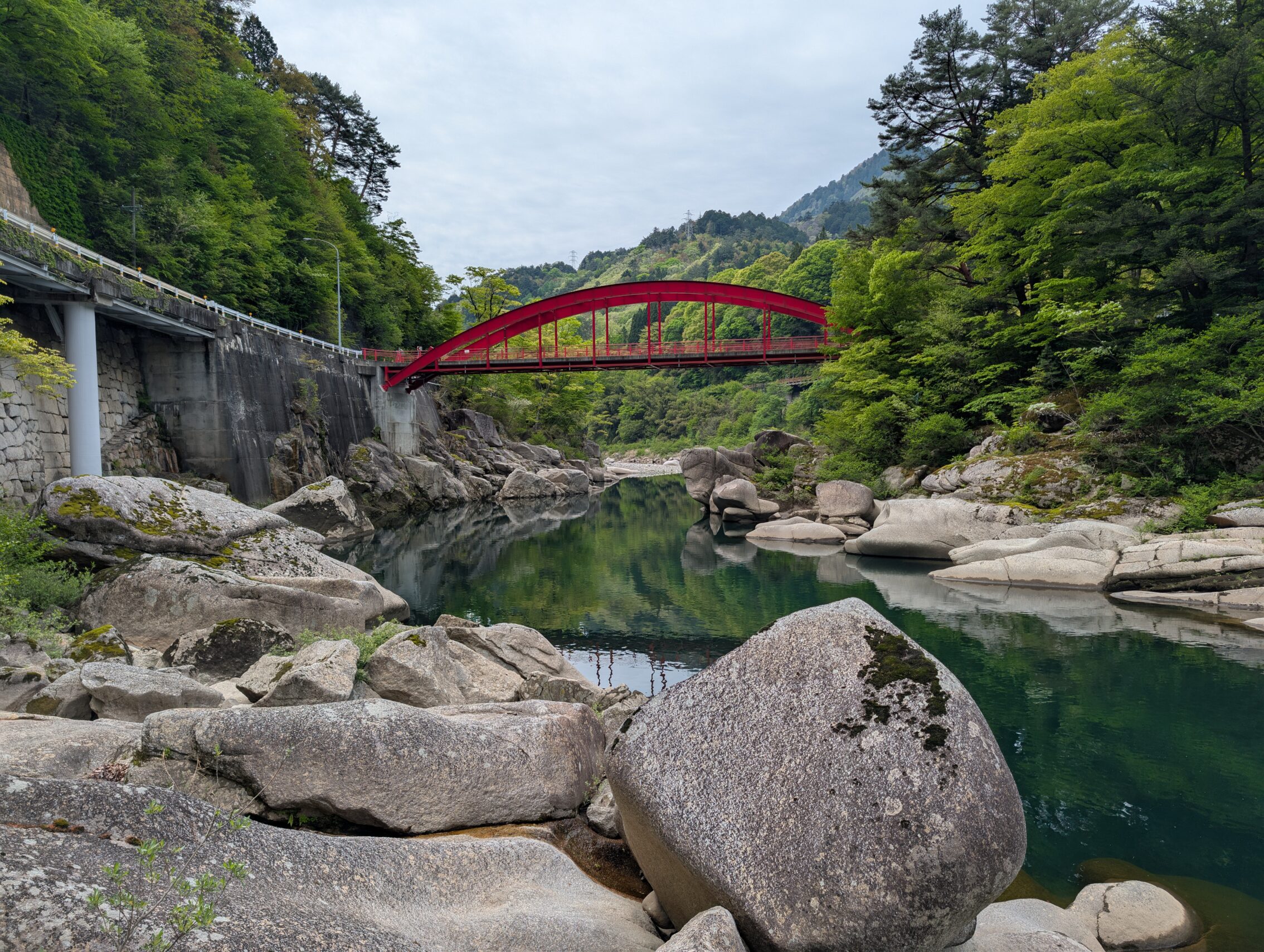 The red Kakehashi bridge as seen from the river.