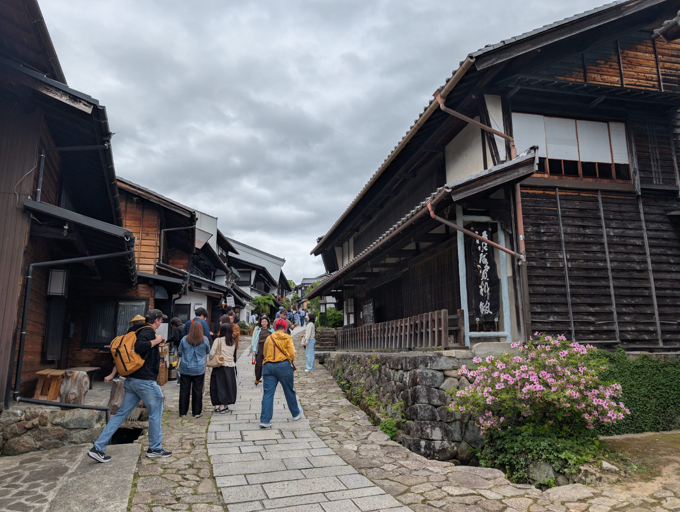 A lively car-free street with old houses on each side.