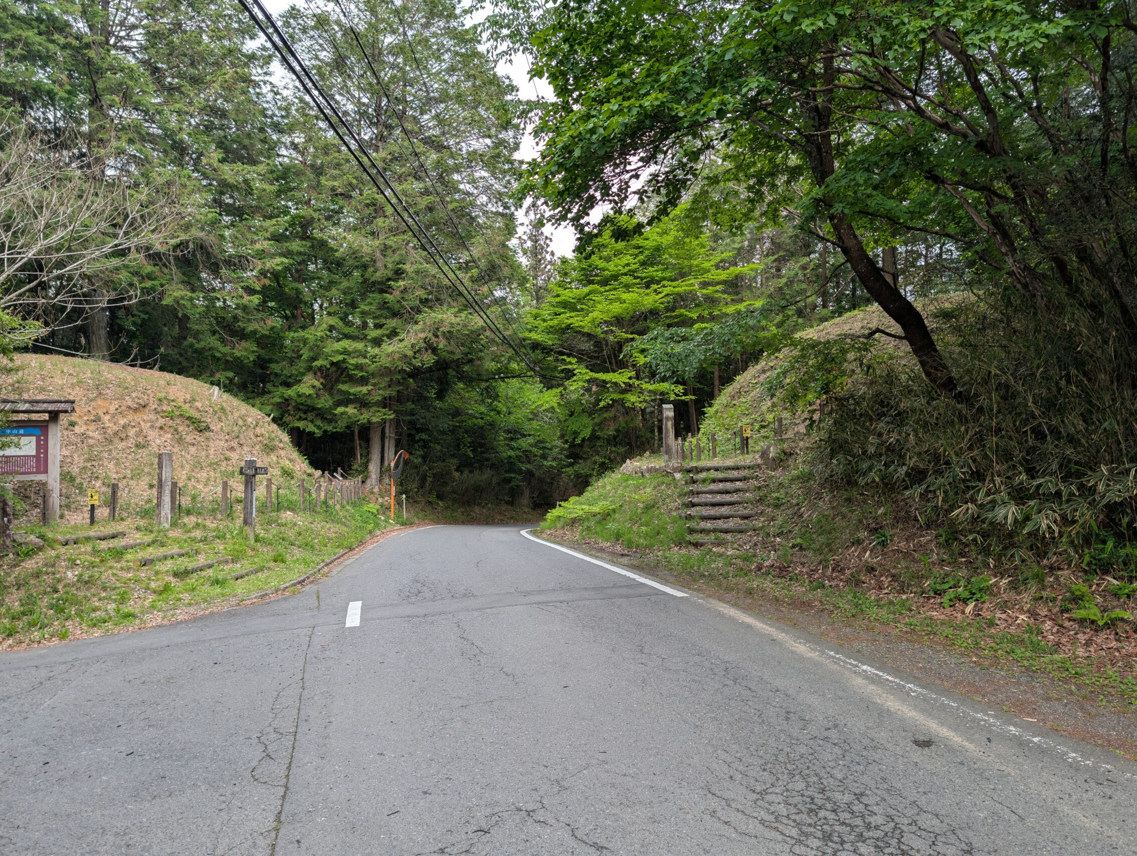 Two earthen mounds, this time with an asphalt road running between them.