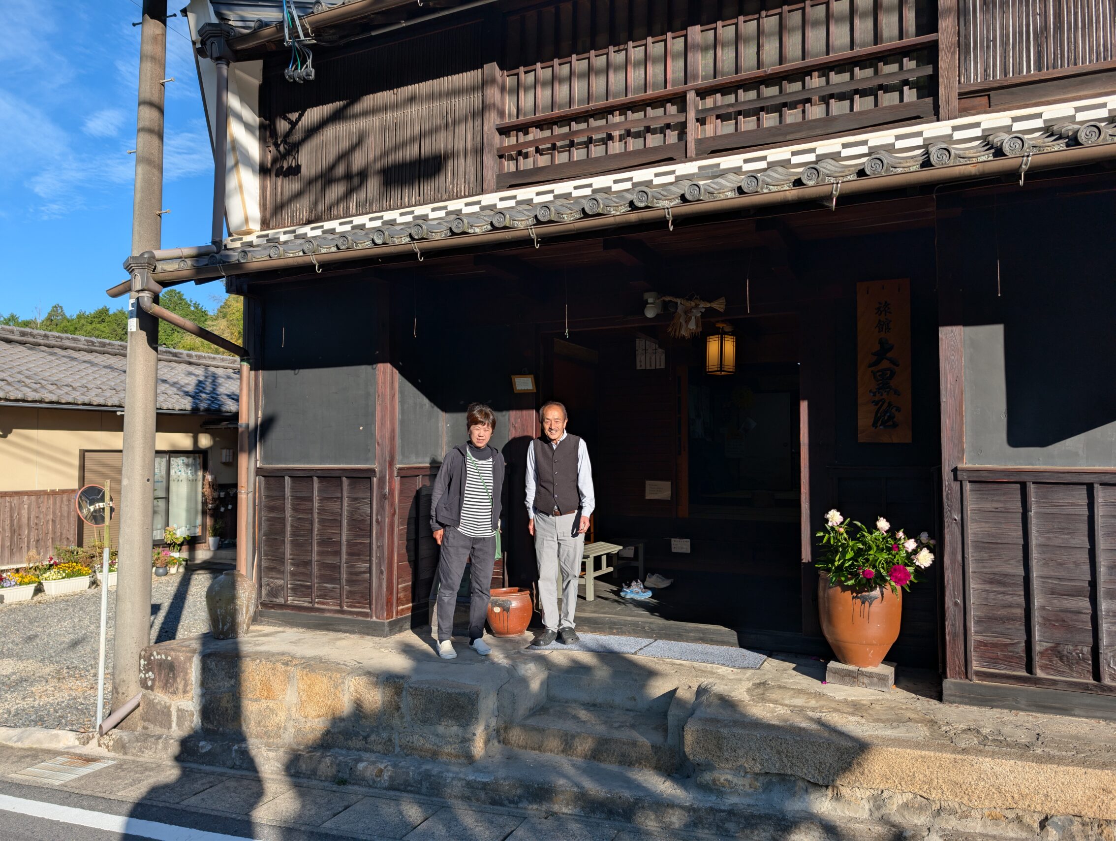 An Edo period house that still functions as an inn. The two owners are standing on the porch.