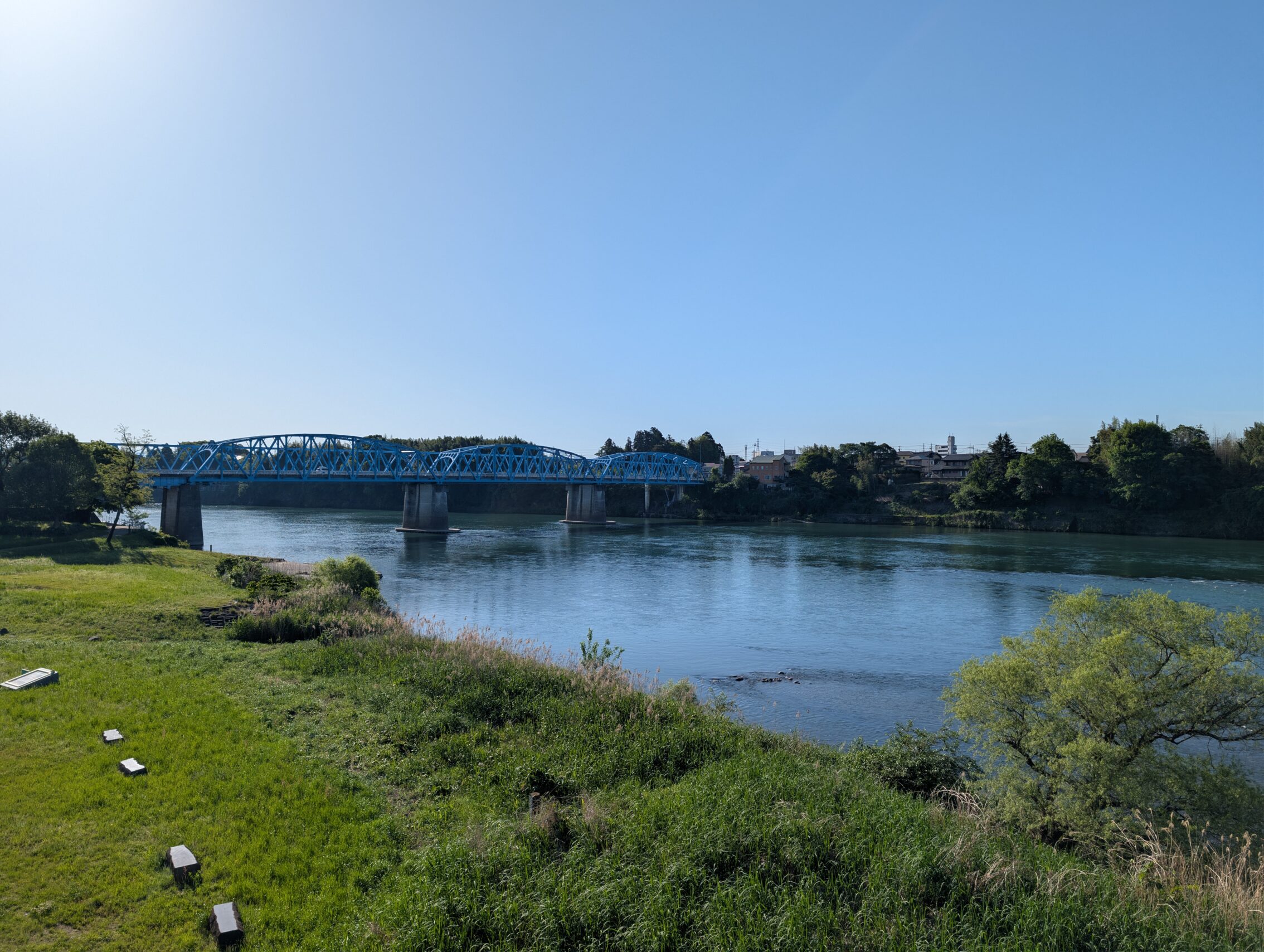 A river with a bridge, under a blue sky.