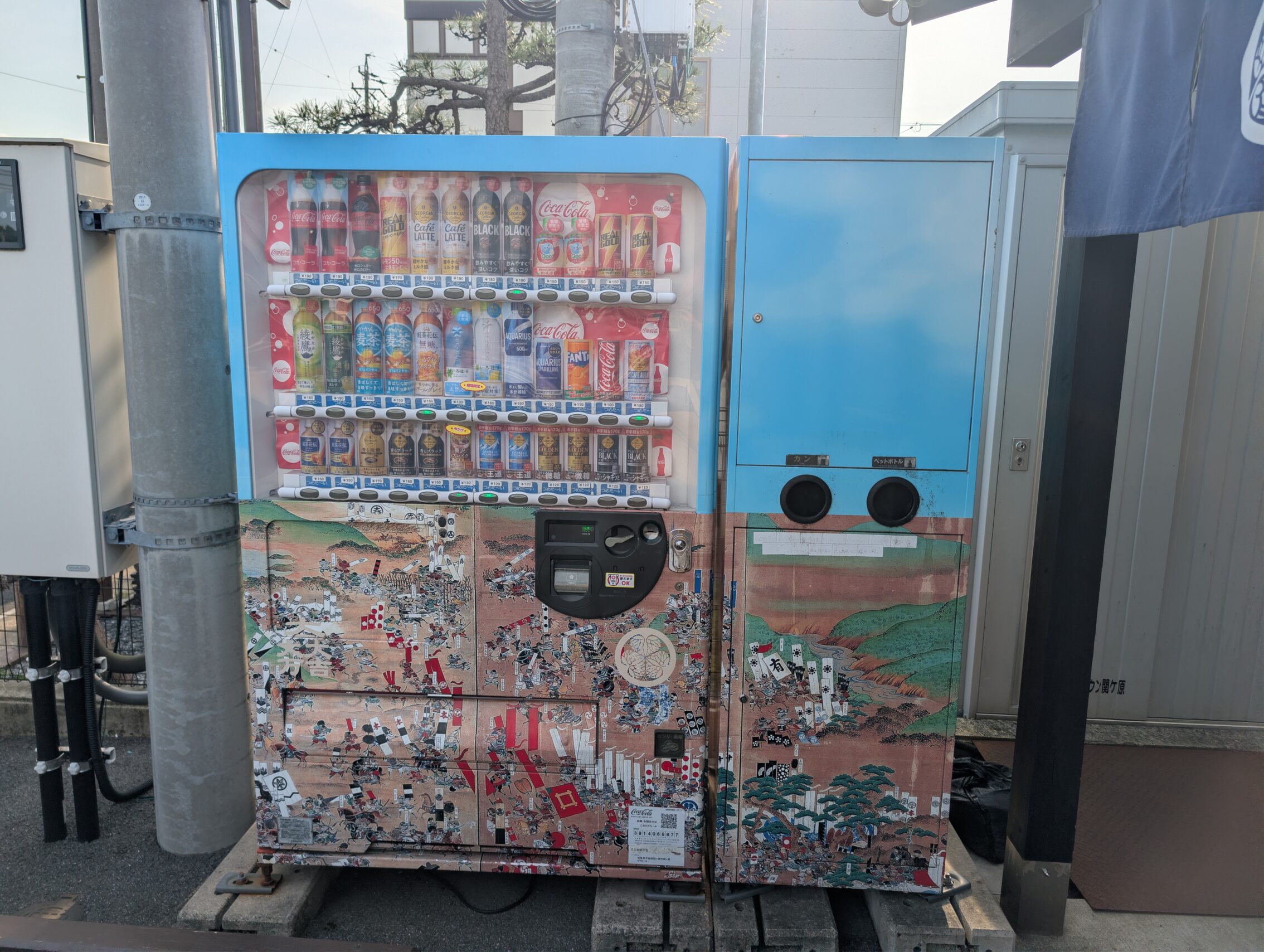 A vending machine with scenes printed on the frame from the 19th century painting of the battle of Sekigahara.
