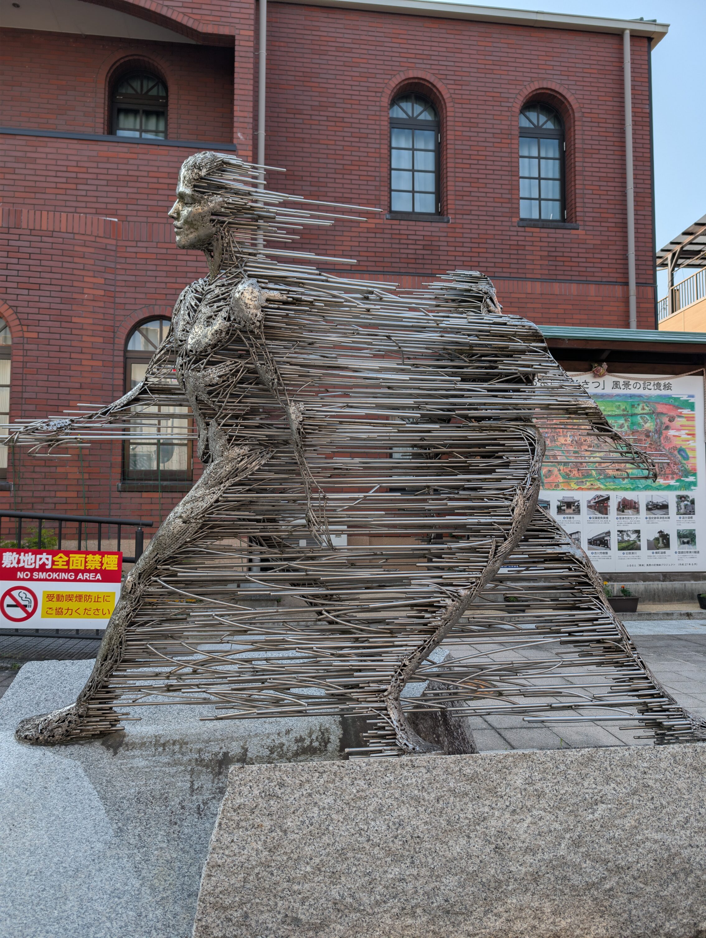 A statue showing two people walking in opposite directions, and there are metal bars holding them together.