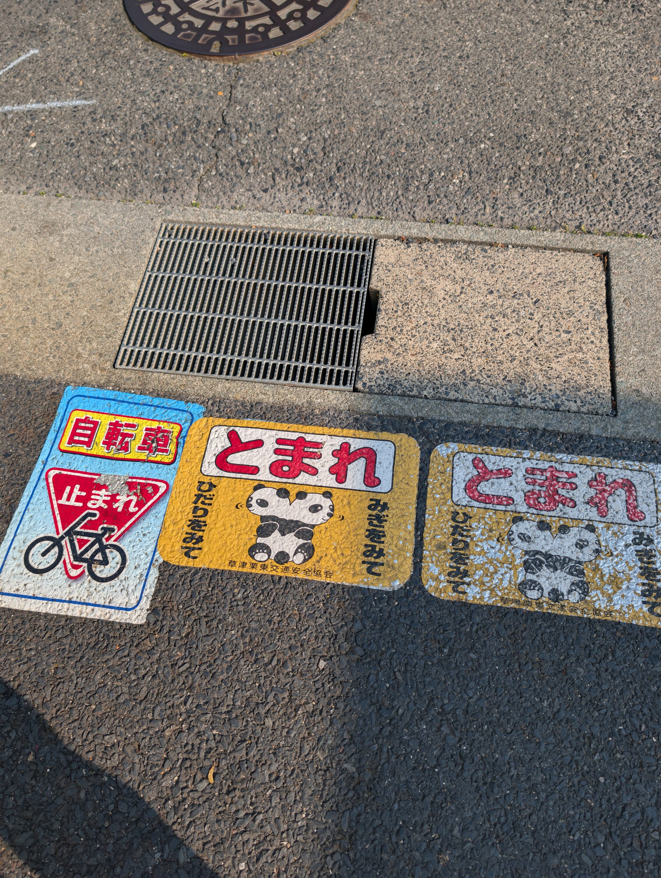A sign on the ground showing a panda with what looks like two heads, looking in both directions. It is supposed to show that is turning its head.