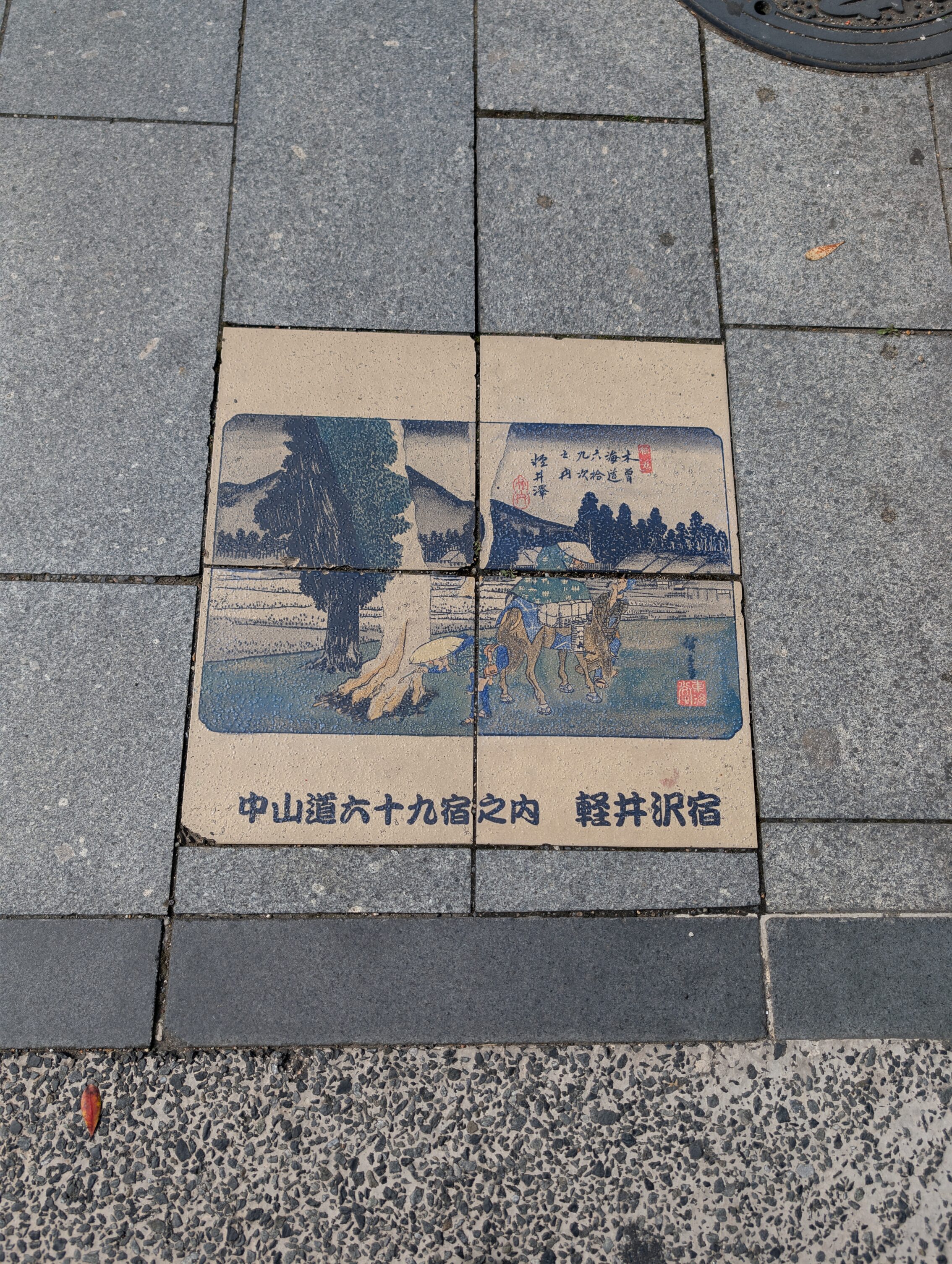 Coloured tiles in the pavement showing a scene from the book 69 Stations of the Kisokaido.