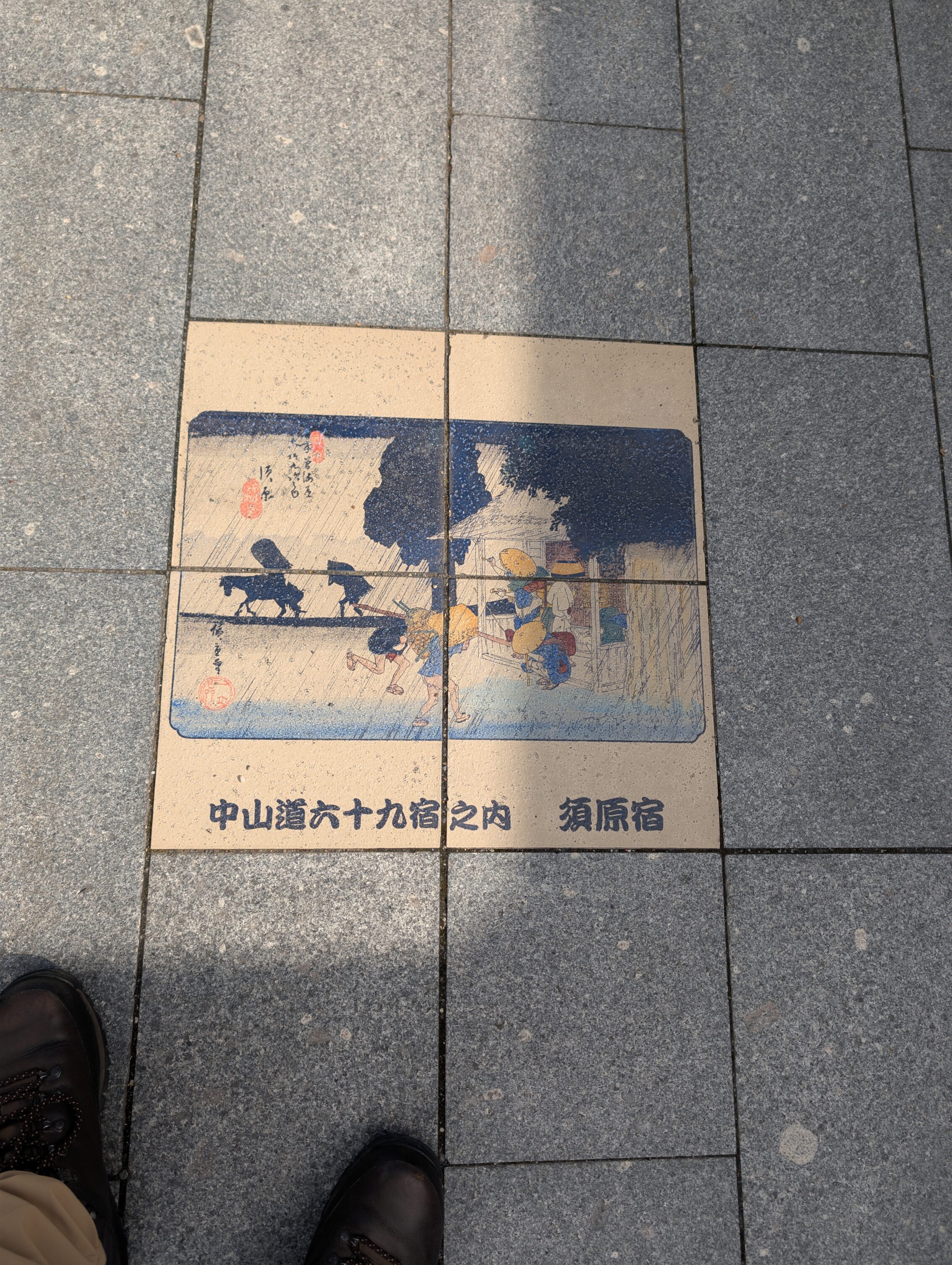 Coloured tiles in the pavement showing a scene from the book 69 Stations of the Kisokaido.