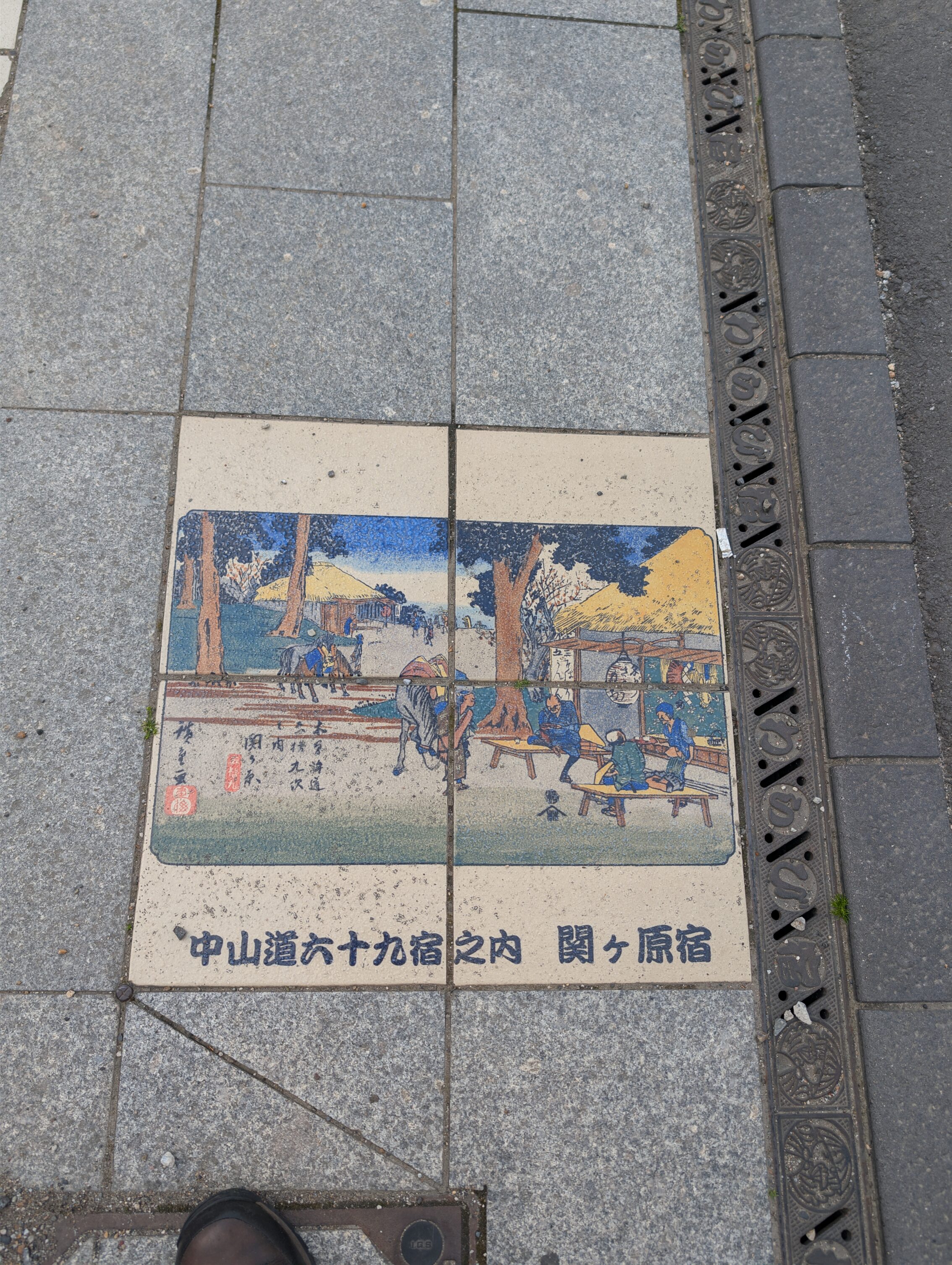 Coloured tiles in the pavement showing a scene from the book 69 Stations of the Kisokaido.